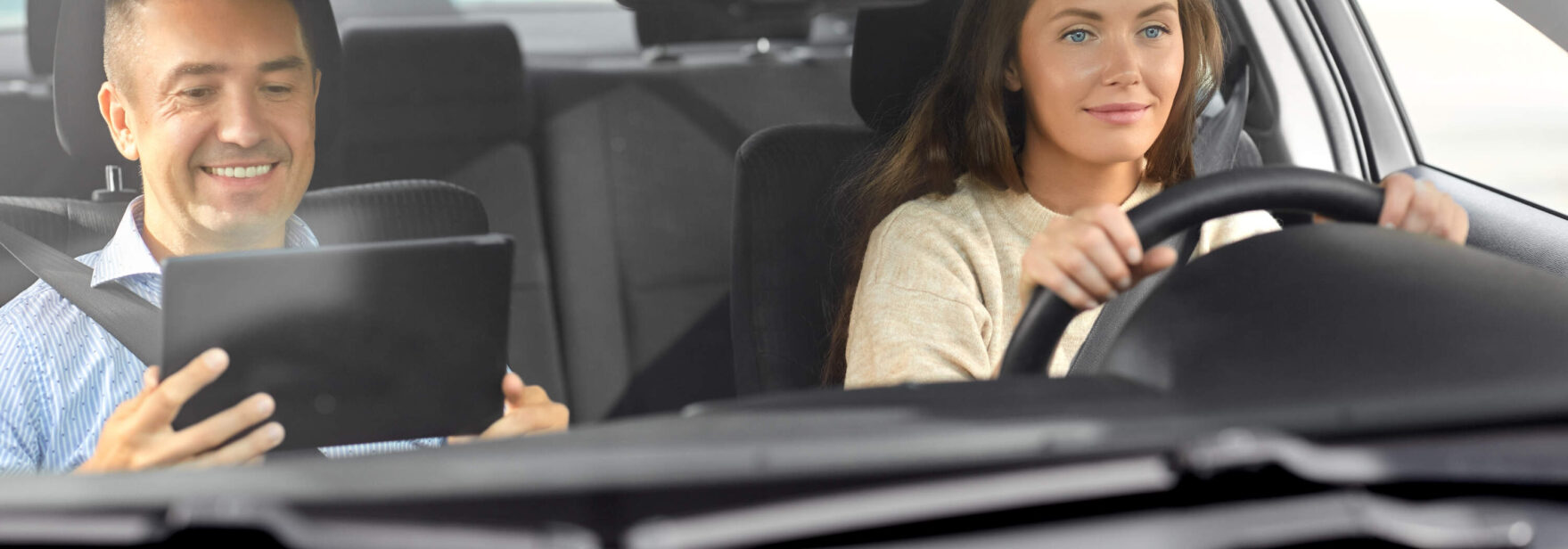 cours de conduite avec moniteur auto-école ayant une tablette