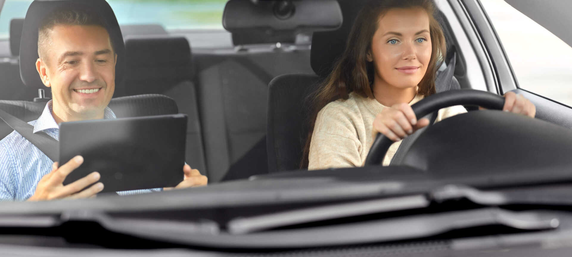 cours de conduite avec moniteur auto-école ayant une tablette