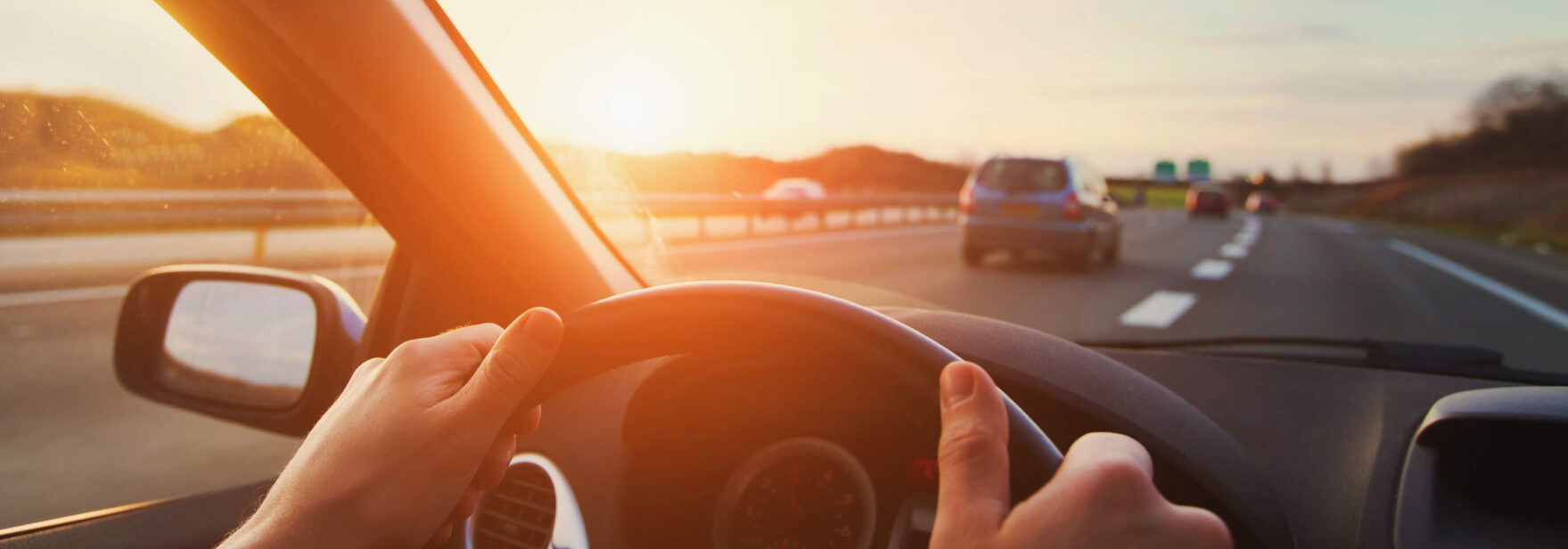 personne conduisant une voiture avec les deux mains sur le volant