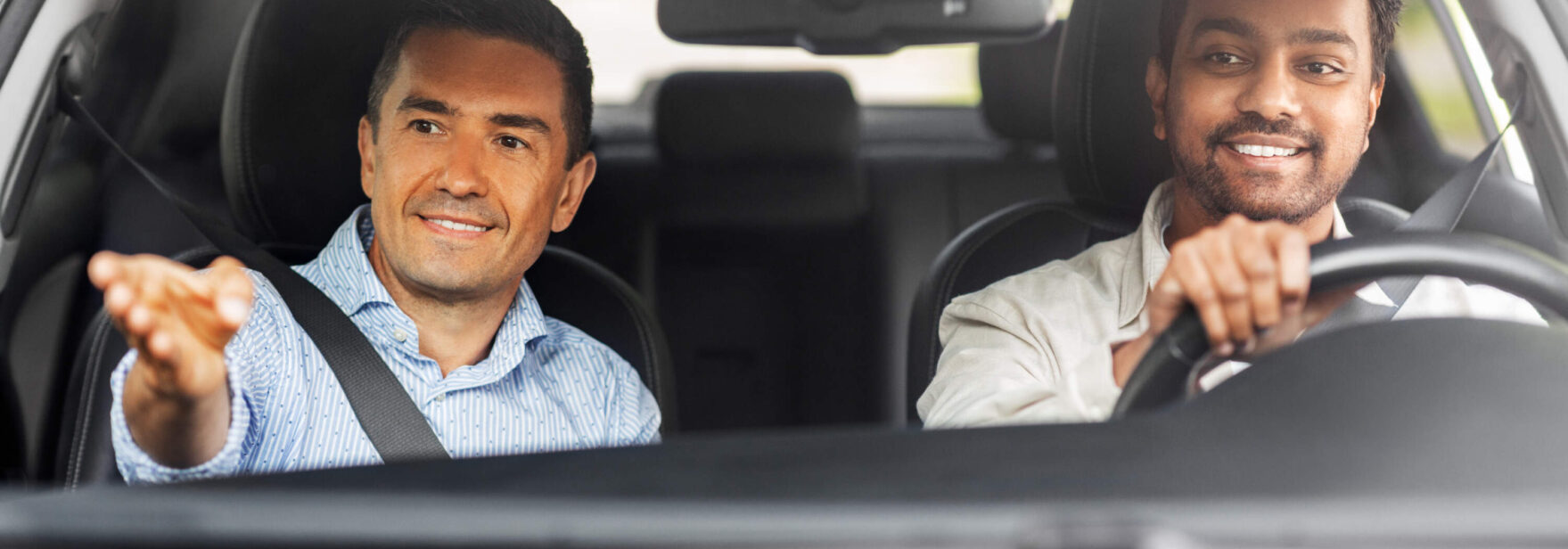 Jeune homme apprenant à conduire une voiture avec son moniteur d'auto-école