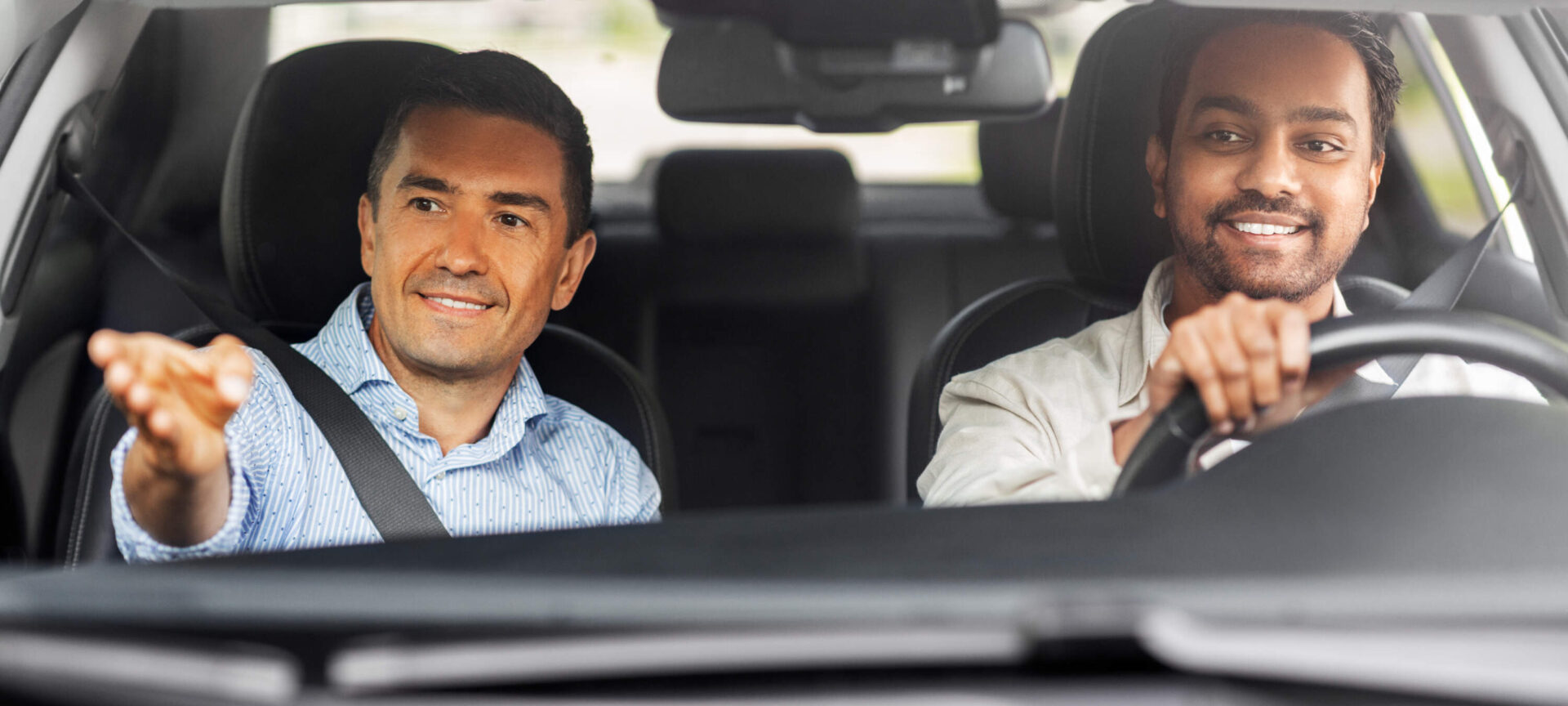 Jeune homme apprenant à conduire une voiture avec son moniteur d'auto-école