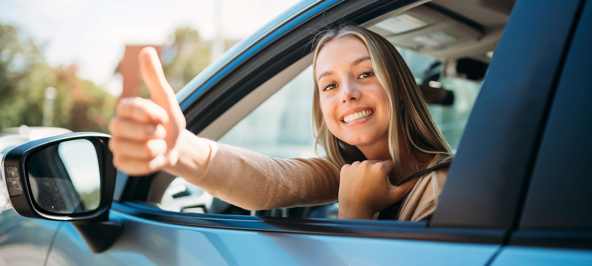 Jeune fille heureuse au volant d'une voiture